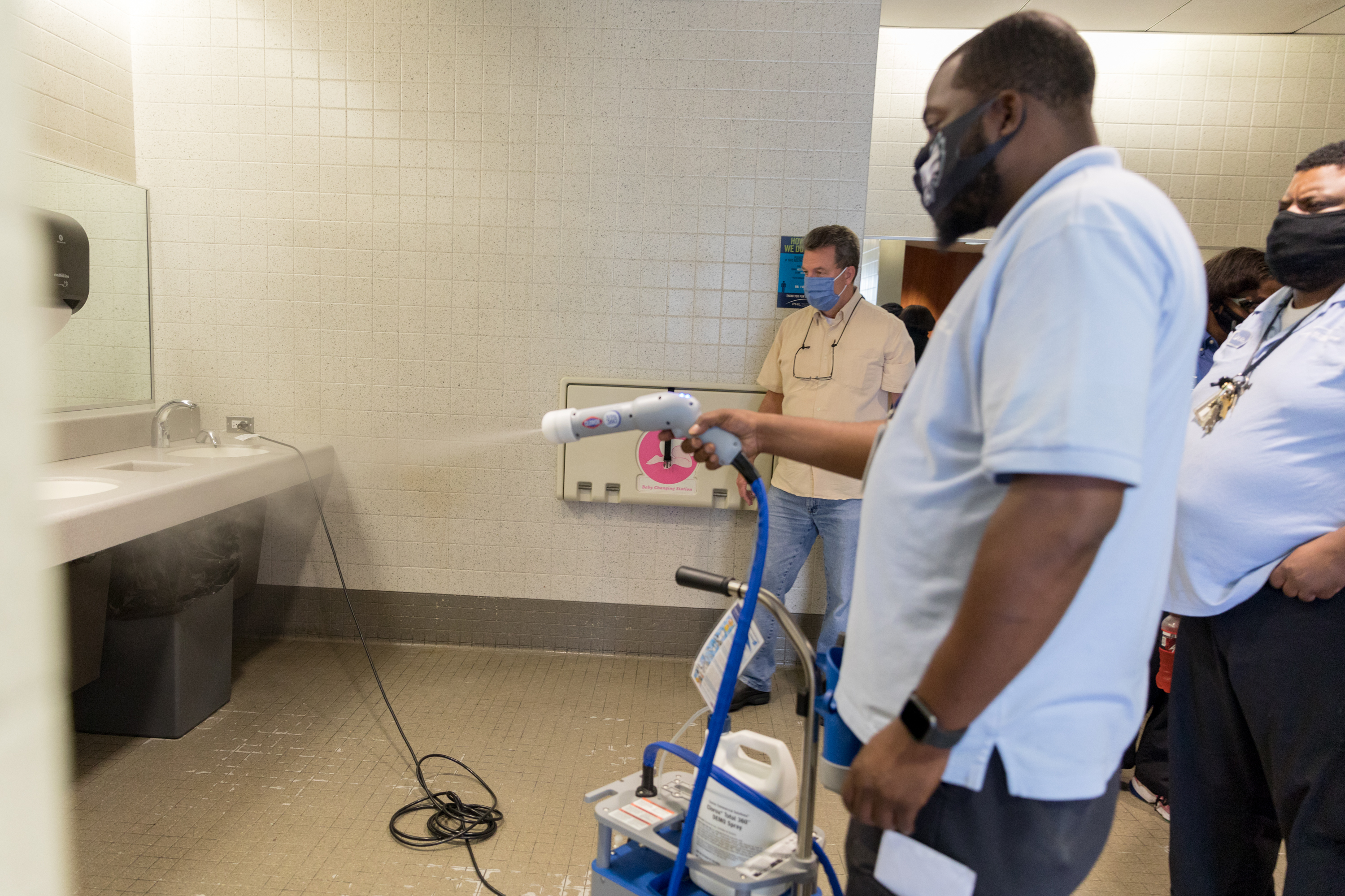 PHL Custodial team sanitizes a restroom with the Clorox 360 electrostatic spraying system