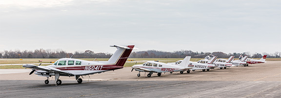 row of private planes all white with red stripes on airfield