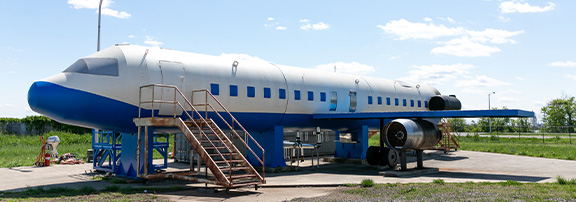 ARFF Training Site Renovation, blue and white plane with steps in front of it