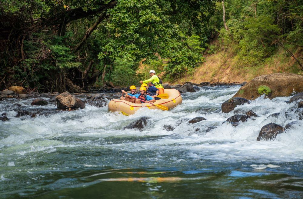 Four people in a raft on rocky waters