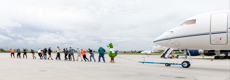 People and Phillies mascot pulling a plane